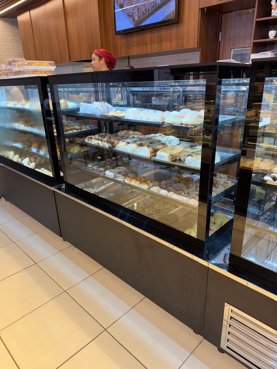 Vitrine refrigerada para frios e embutidos integrada ao balcão de madeira da padaria